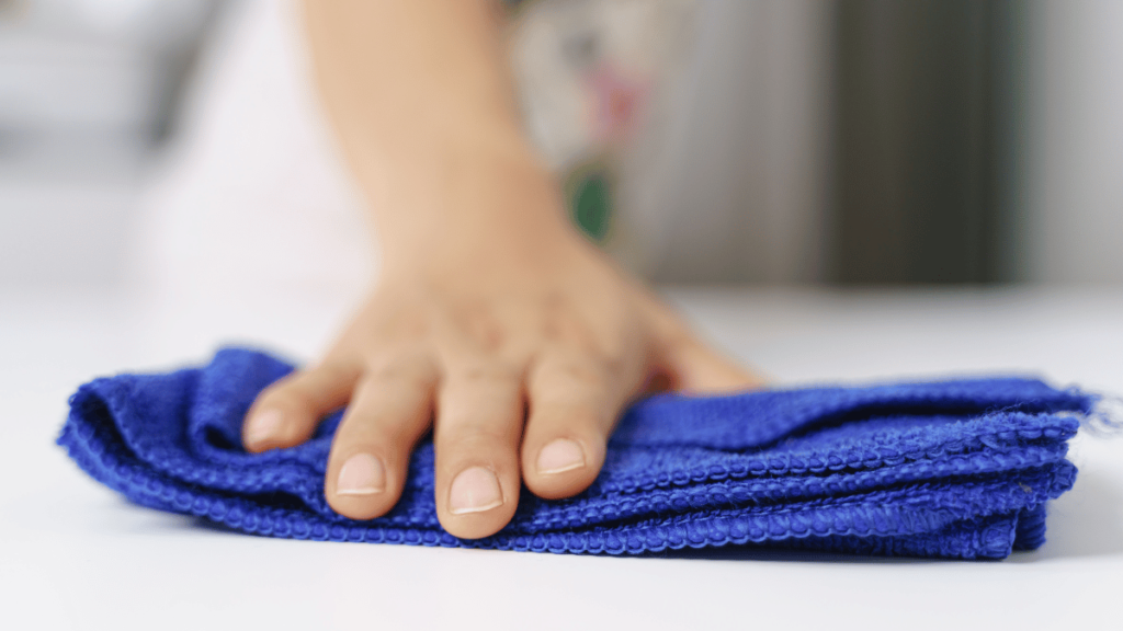 Cleaning table surface by using blue microfiber cloth for dust