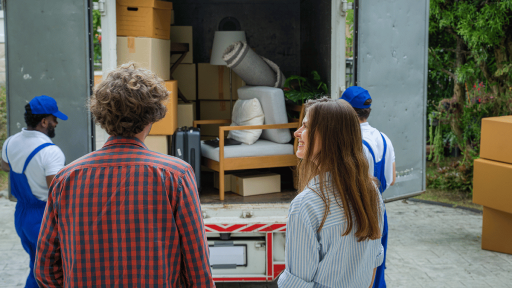 Happy couple with moving boxes at new house,Moving company employee checks boxes in a truck before sending them to the homeowner.