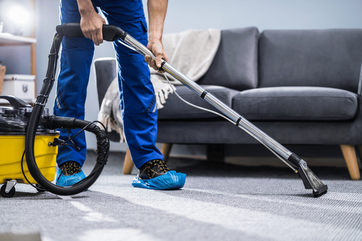 Janitor Cleaning Carpet With Vacuum Cleaner